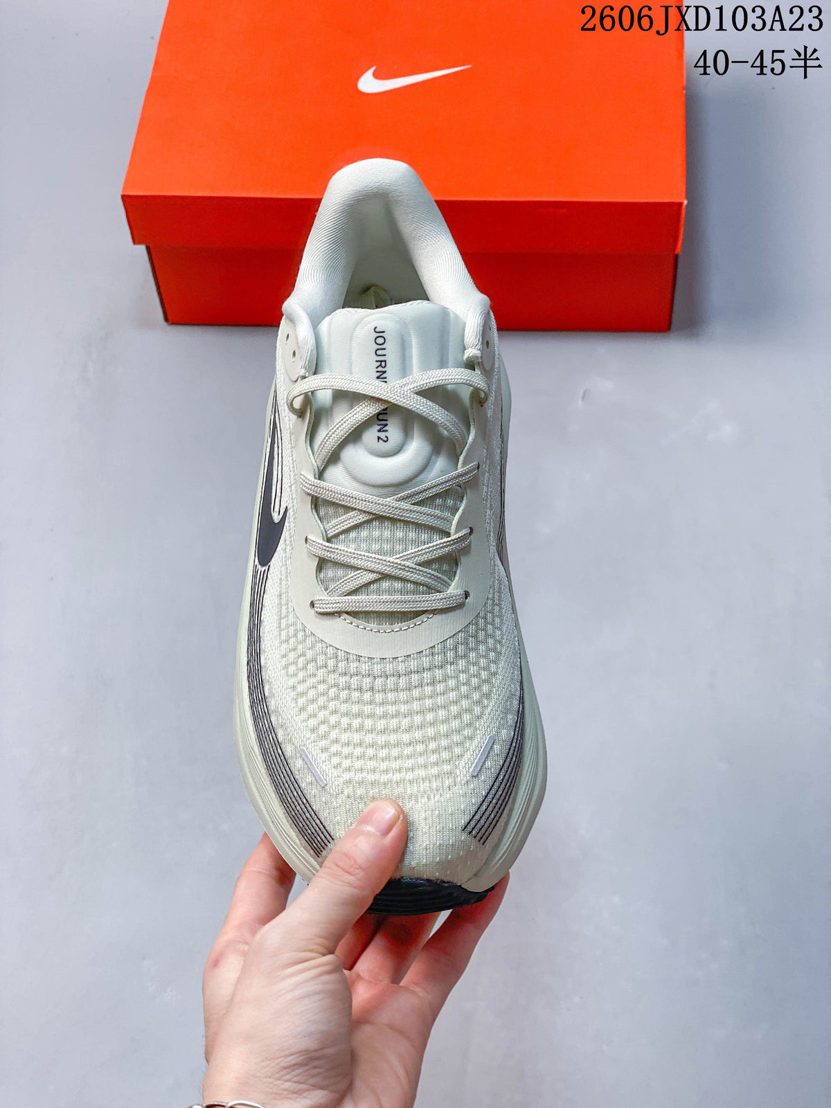 Top view of a light gray running shoe with laces and patterned upper