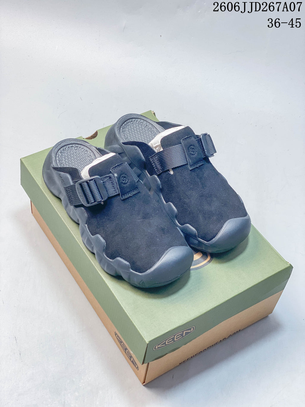 Pair of dark navy KEEN closed-toe clog sandals with adjustable straps, displayed on a shoe box.