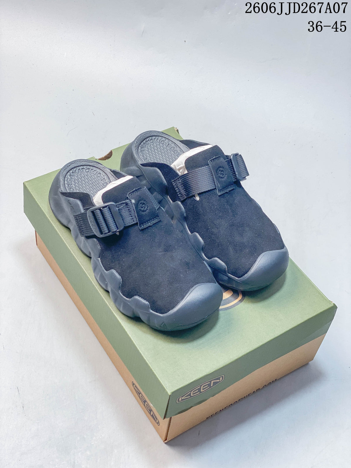 Pair of dark navy KEEN closed-toe clog sandals with adjustable straps, displayed on a shoe box.