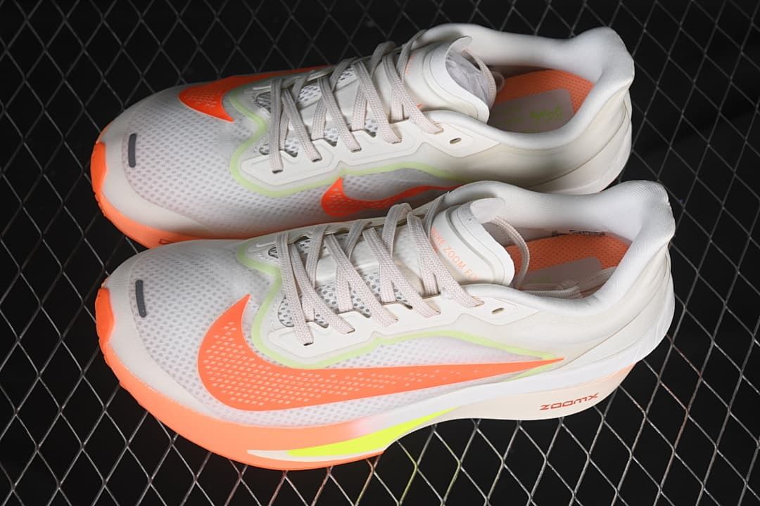Pair of off-white Nike Zoom Fly 6 shoes with orange and neon yellow-green details.