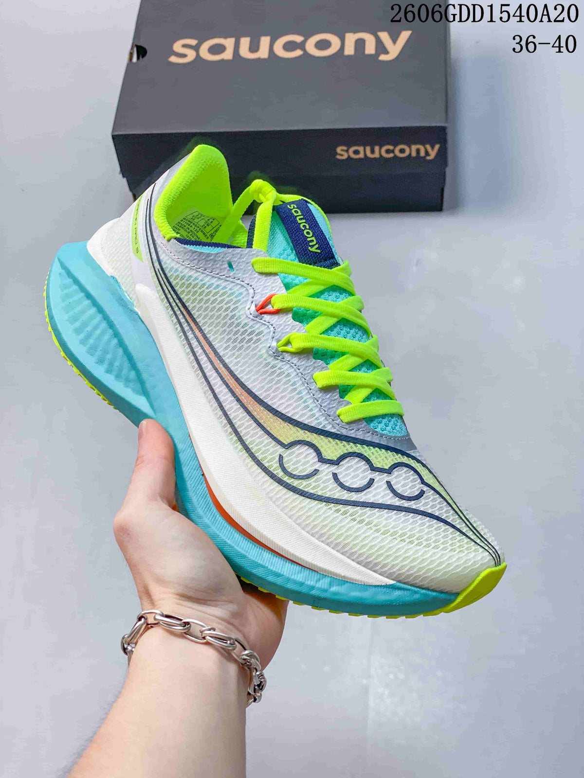 Side view of a light-colored Saucony running shoe with turquoise sole accents and bright laces.