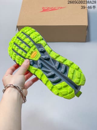 Underside showing the trail shoe's deeply lugged neon yellow-green outsole