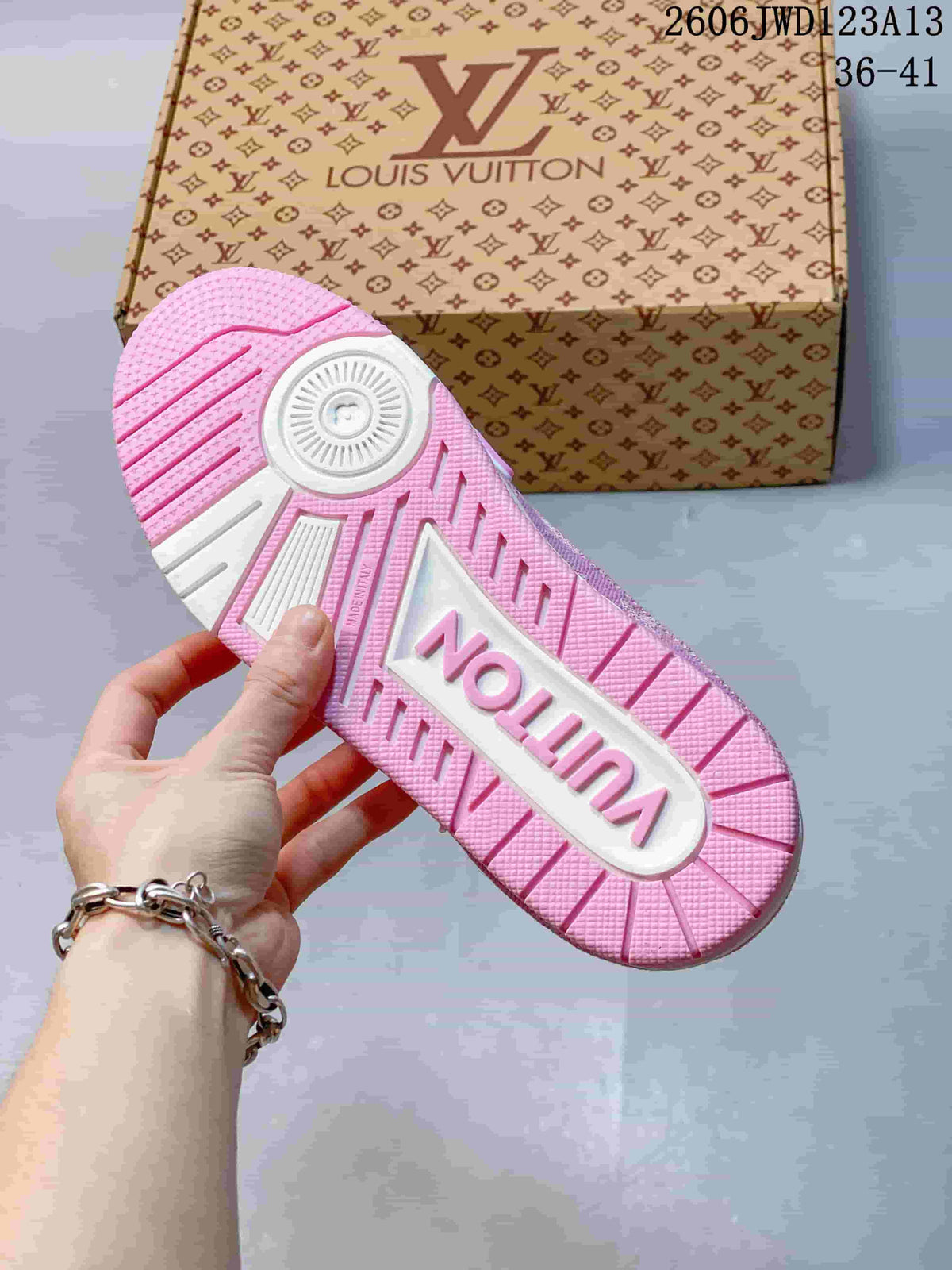 Close-up of the pink-and-white sneaker outsole with patterned tread and a branded box in the background; image text shows code 2606JWD123A13 and sizes 36–41.