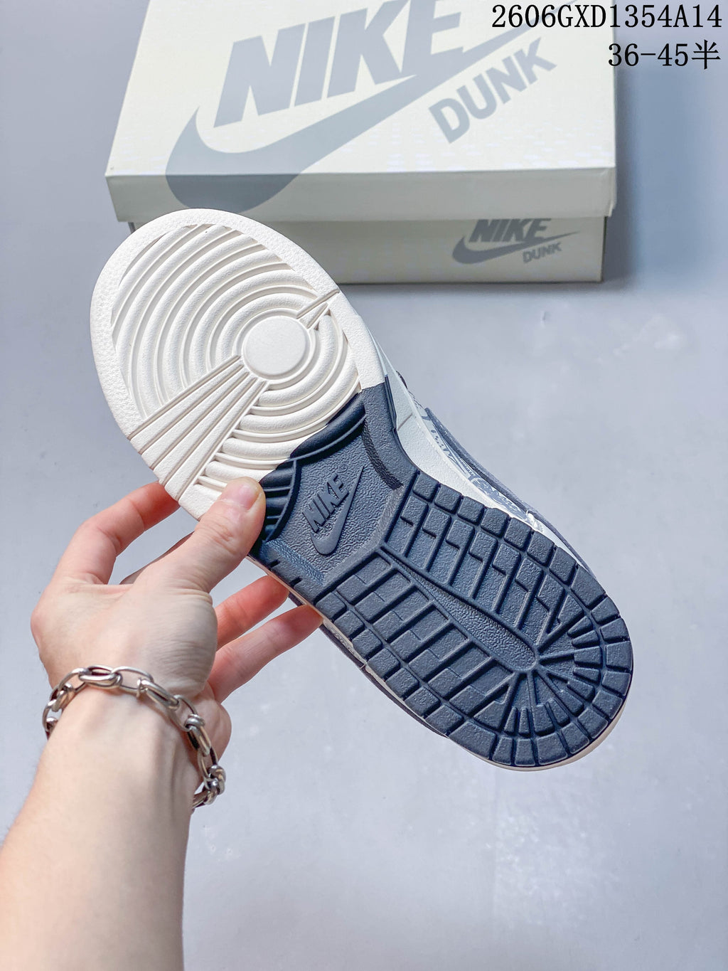 Underside of the sneaker showing a two-tone white and navy outsole