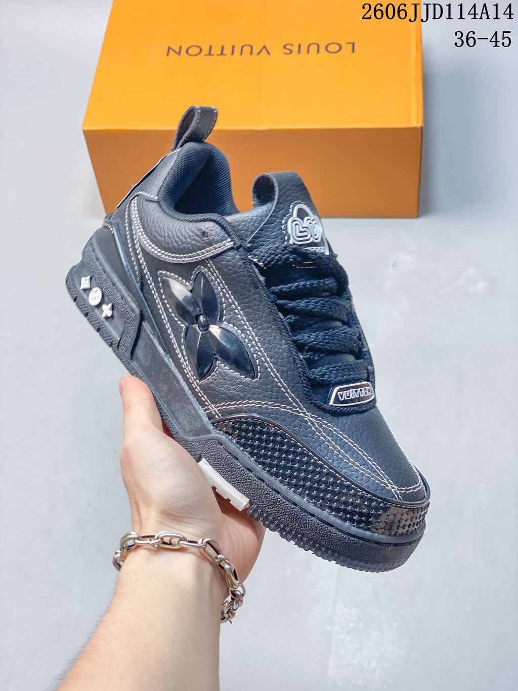 Angled side view of the charcoal low-top sneaker with a decorative side motif