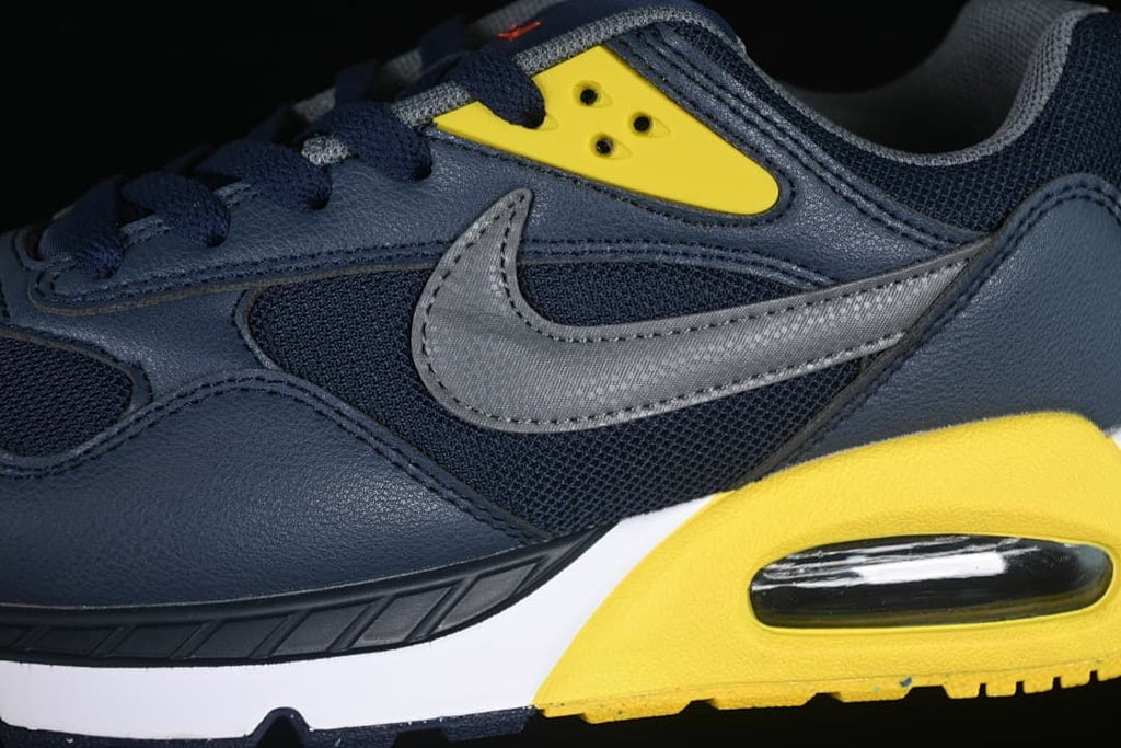 Close-up of the gray side Swoosh, yellow eyelet panel, and heel cushioning unit.