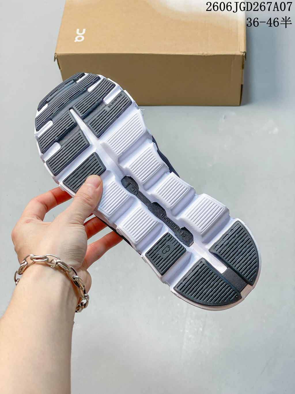 Underside of the sneaker showing its segmented white outsole and dark tread sections.