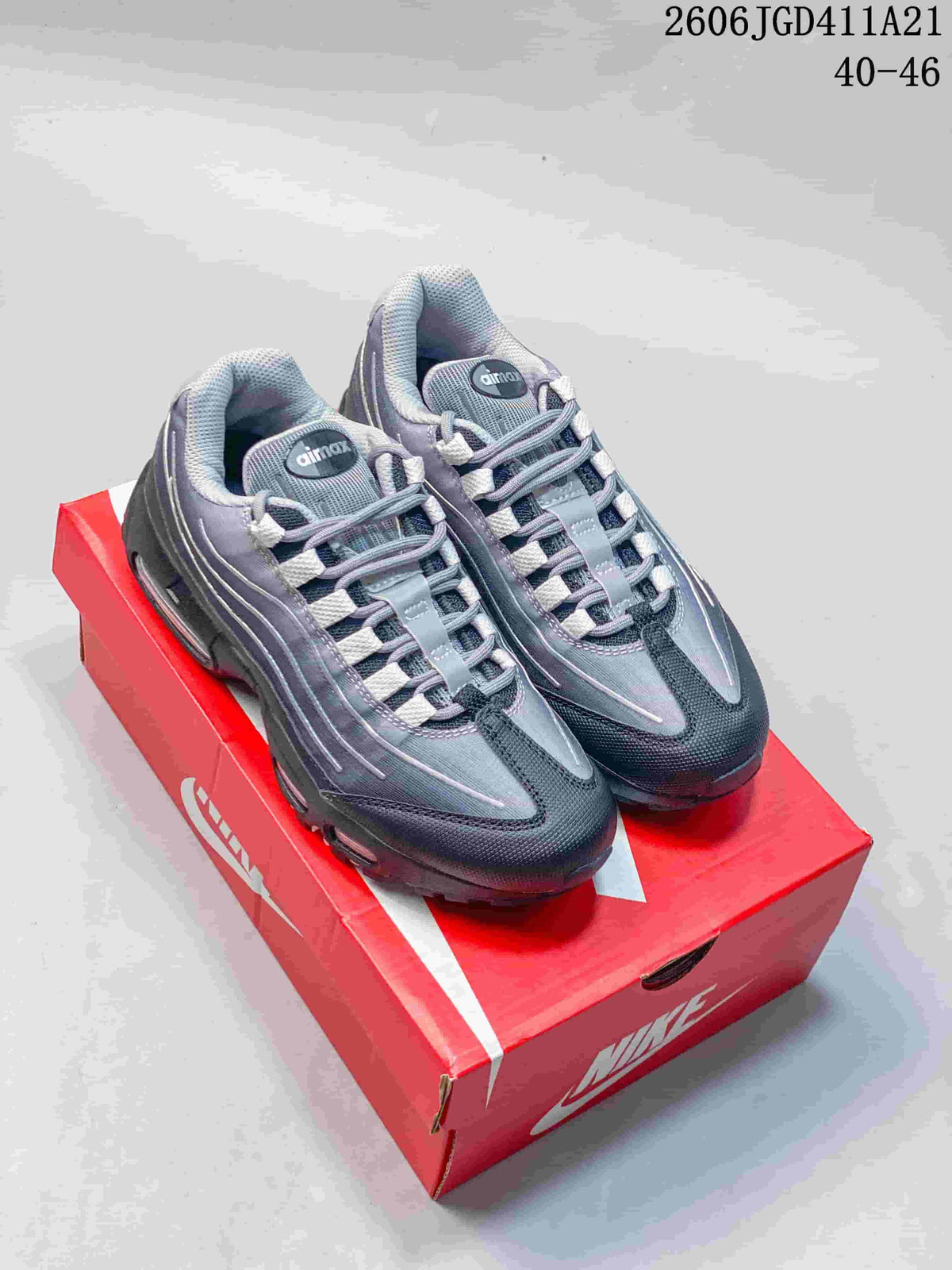Gray and dark Nike Air Max 95 sneakers with pale accents, shown on a red shoe box