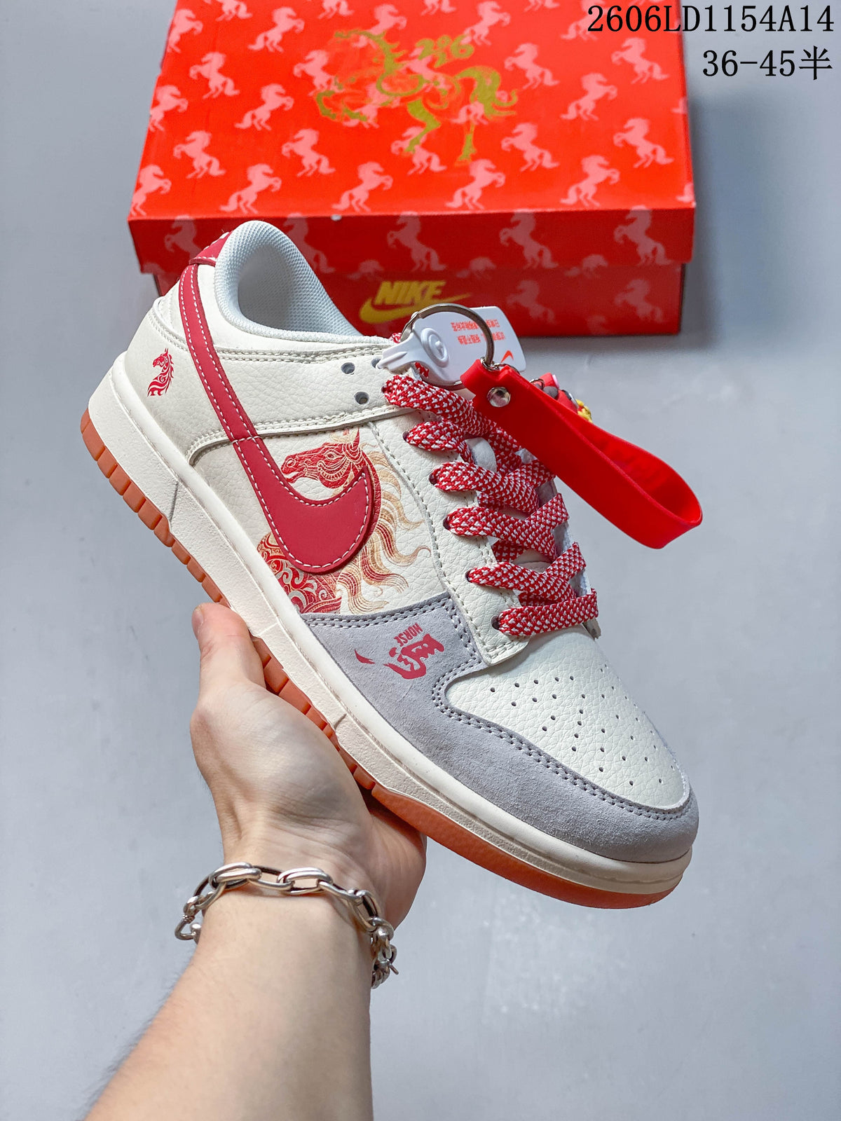 Close-up of an off-white and red low-top sneaker with patterned side panels, red-and-white laces, and hanging charms.