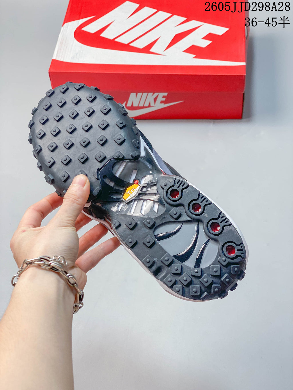 Underside view showing the lugged outsole of a gray and black sneaker