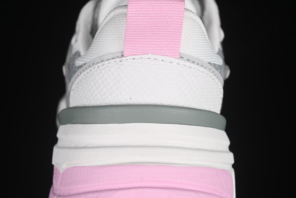 Rear close-up of the sneaker with a pink heel pull tab and layered sole