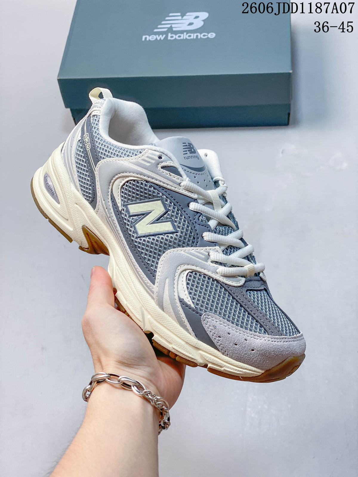 Angled side view of the grey and blue-grey sneaker with a prominent side logo and off-white accents.