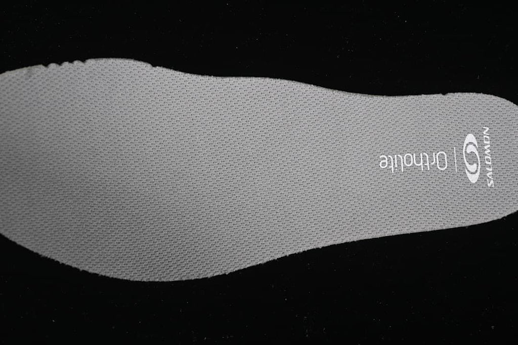 Gray Salomon OrthoLite insole viewed from above.