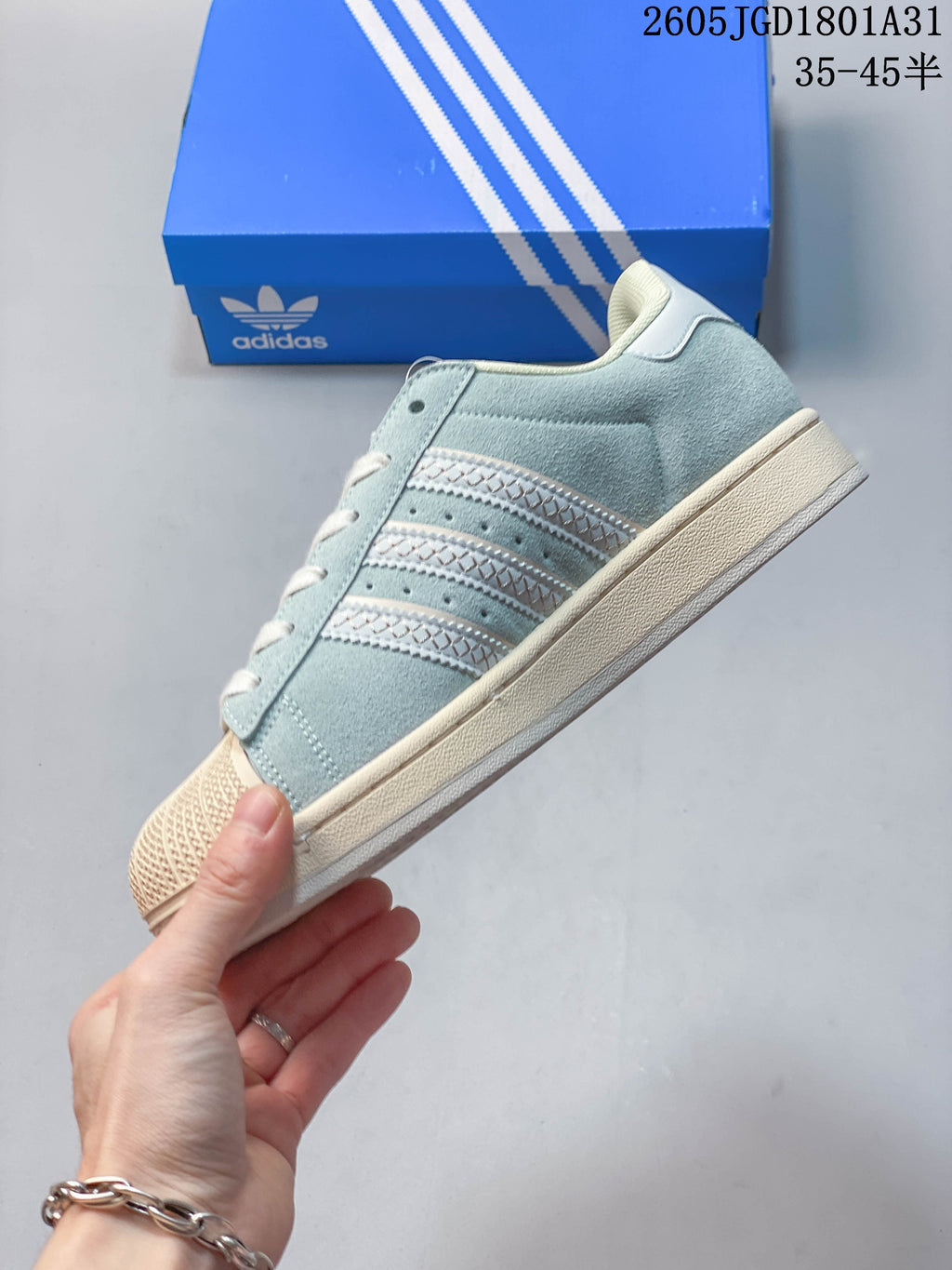 Side view of the light blue sneaker with three decorative stripes