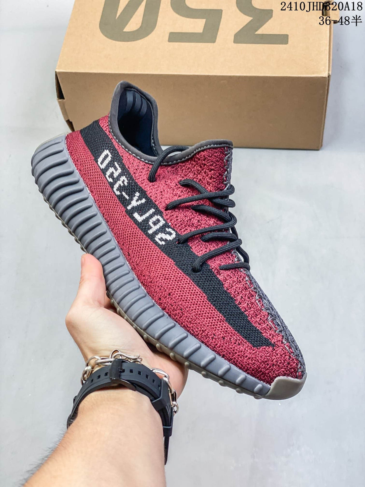Side view highlighting the red upper, black stripe, and gray ribbed sole