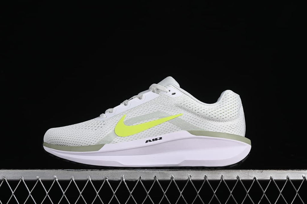 Side view of a white Nike Winflo 11 shoe with a bright volt Swoosh.