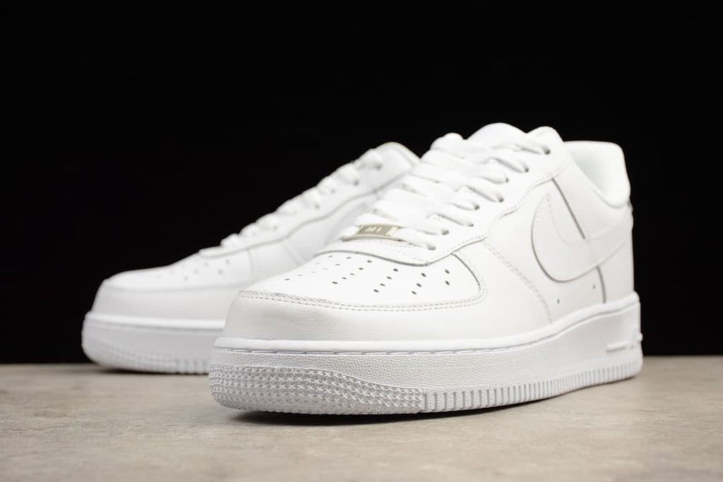 Angled front view of the pair of white low-top sneakers.