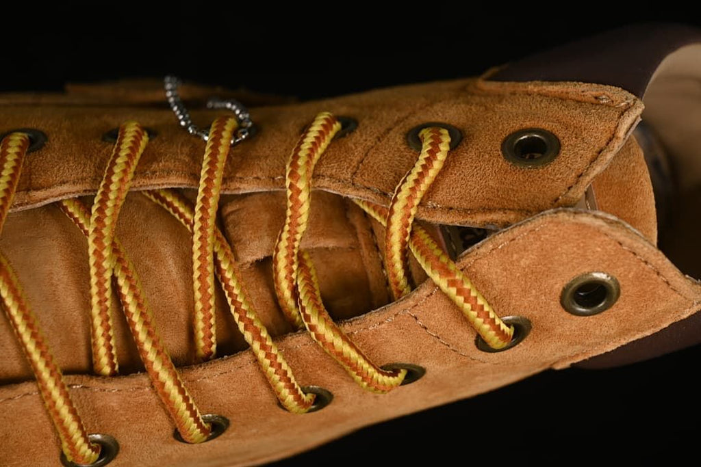 Close-up of yellow-and-red laces threaded through metal eyelets