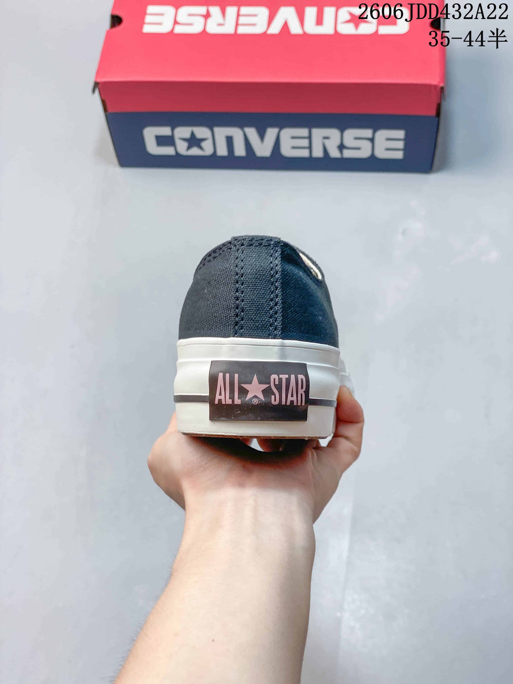 Rear view of a navy Converse All Star sneaker showing the heel label