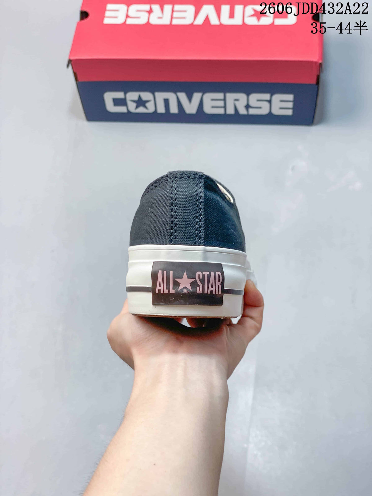 Rear view of a navy Converse All Star sneaker showing the heel label