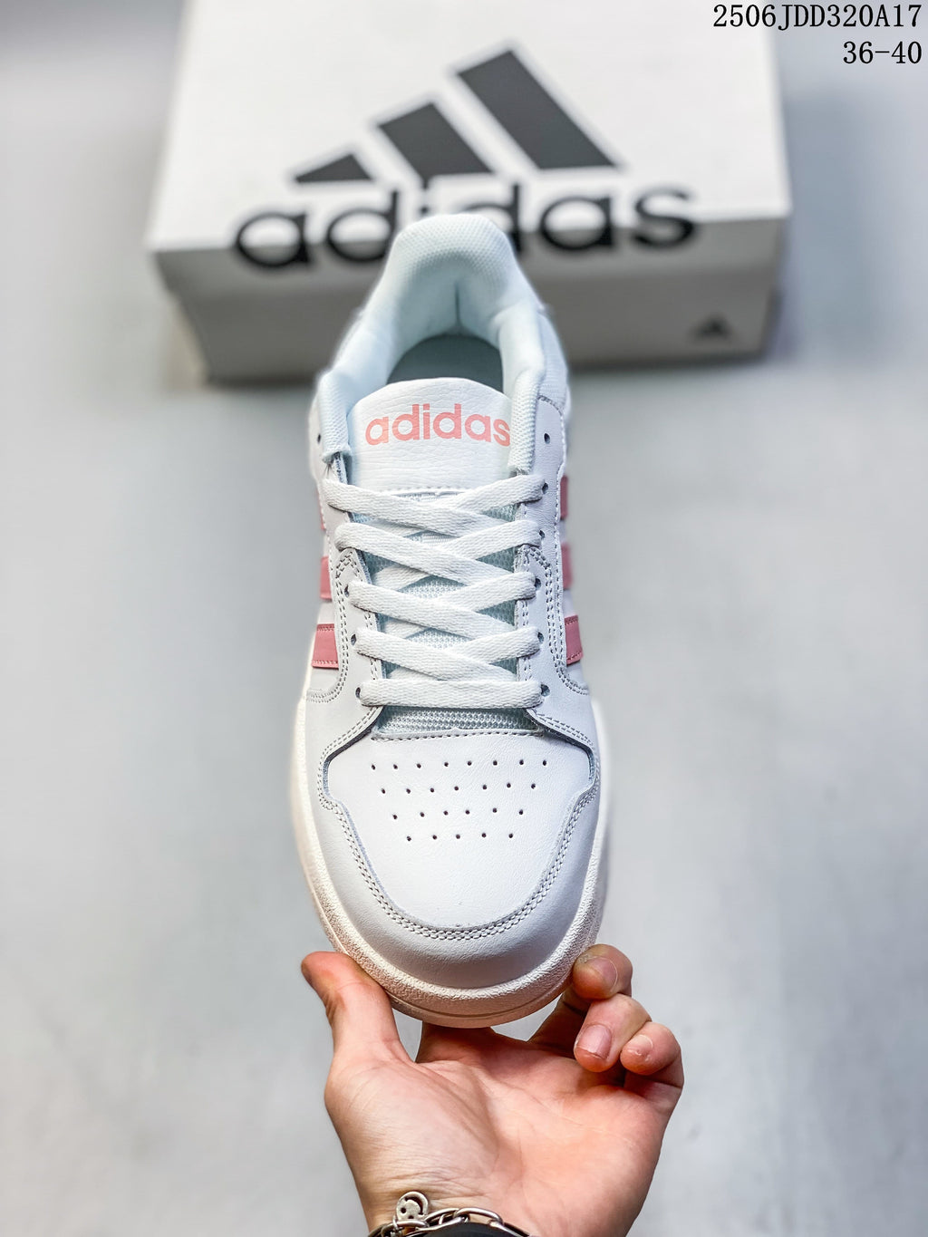Front view of a white adidas sneaker with a perforated toe and pink tongue logo