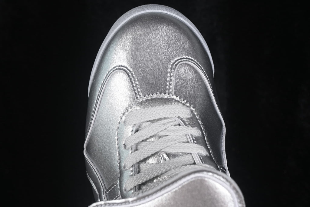 Close-up of the silver sneaker toe box, stitching, and tonal laces.