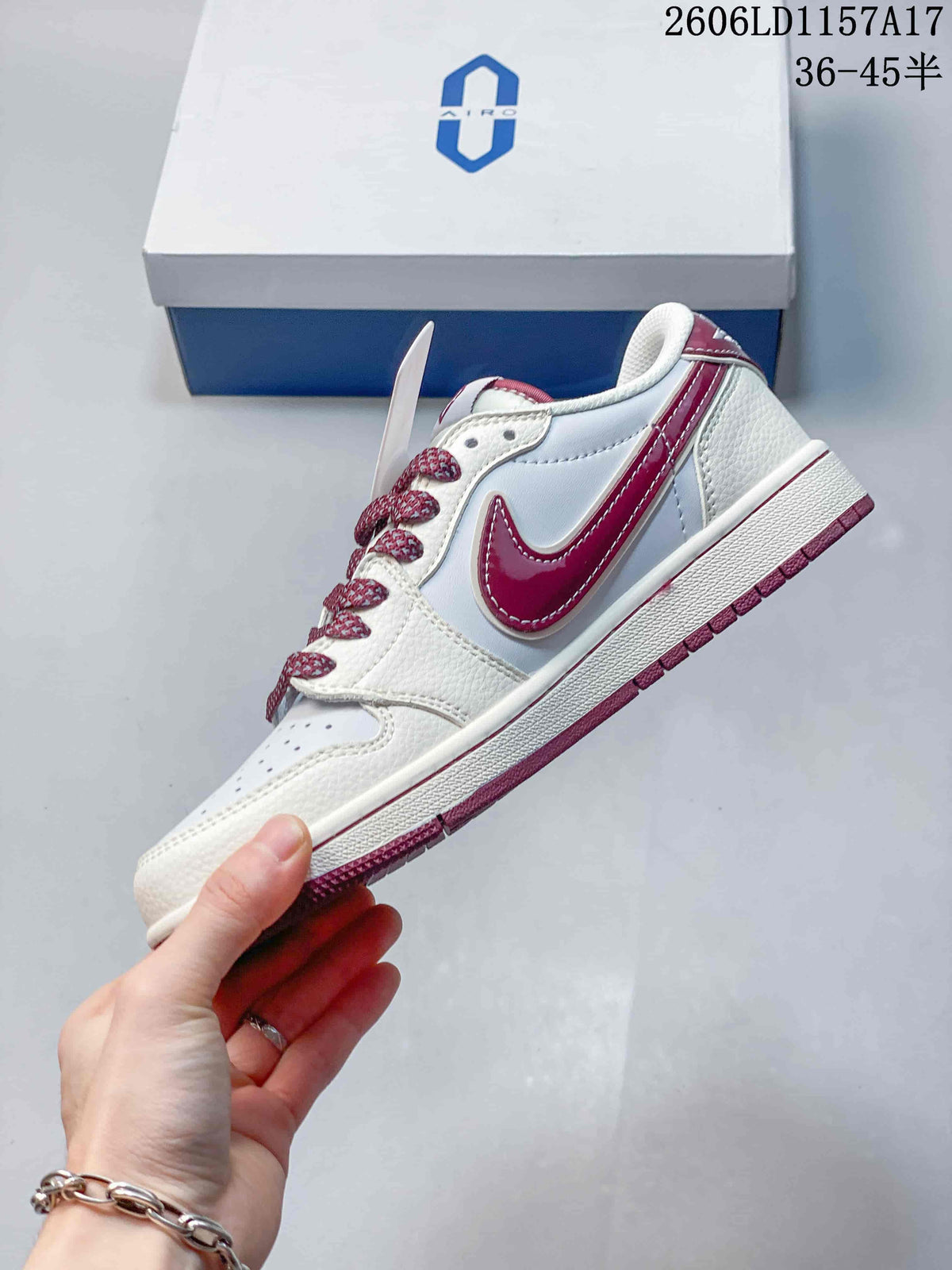 Side view of a white low-top sneaker with burgundy Swoosh and outsole