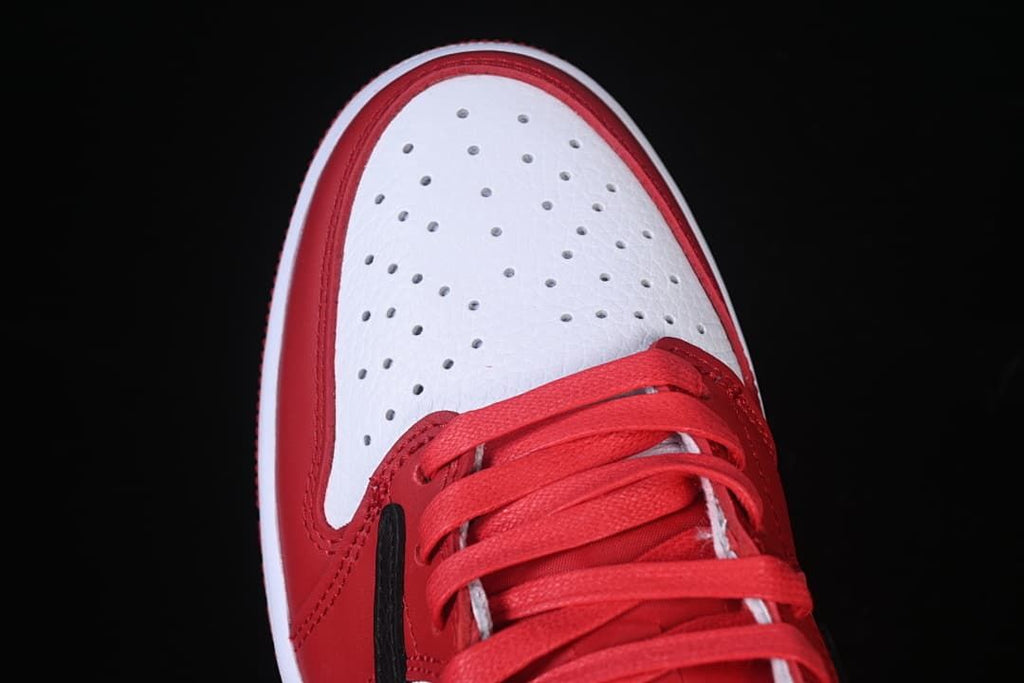 Top view of the white perforated toe and red laces.