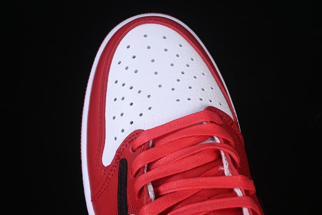 Top view of the white perforated toe and red laces.