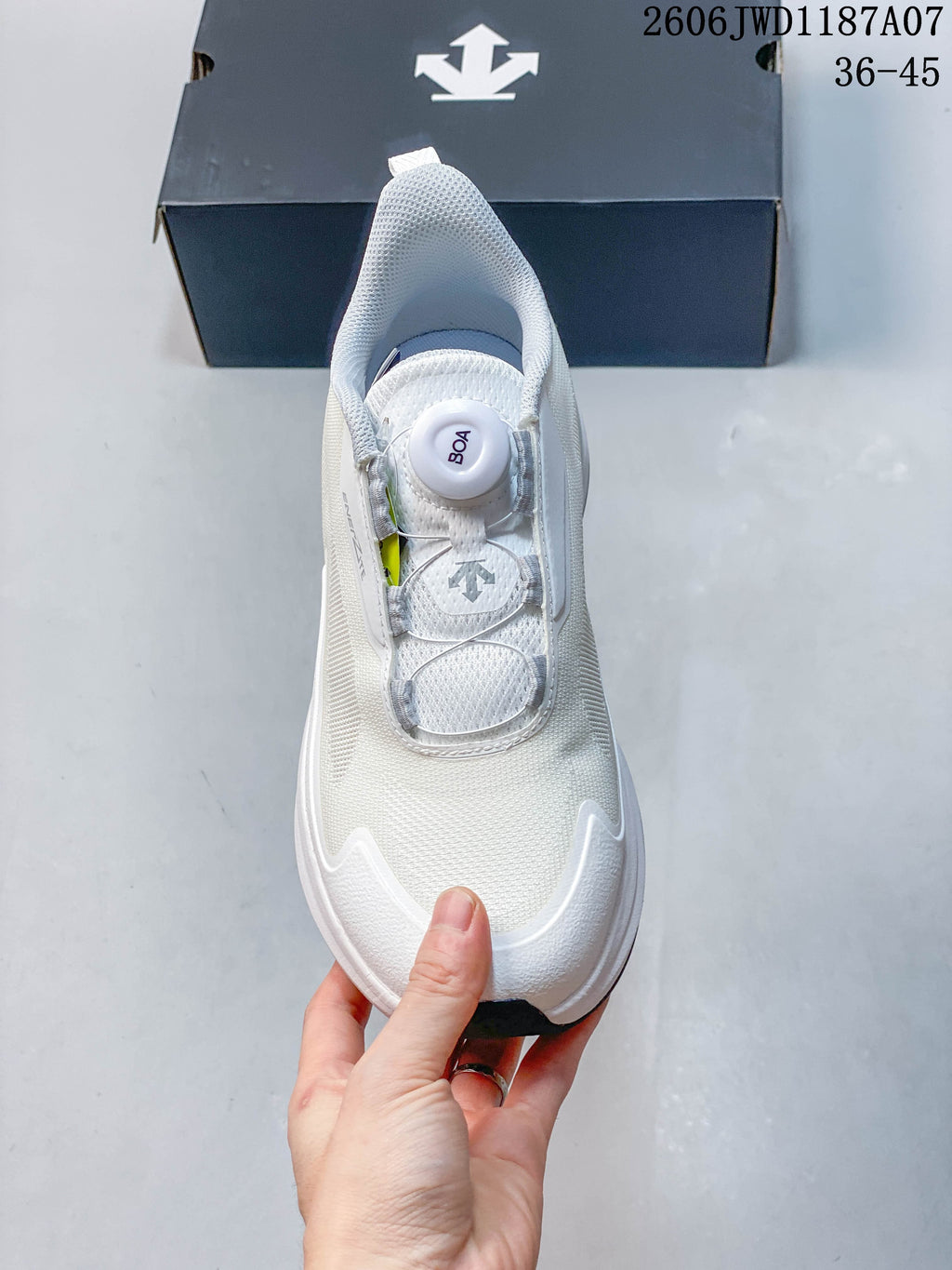 Top view of the white shoe showing its dial closure and mesh-look upper.