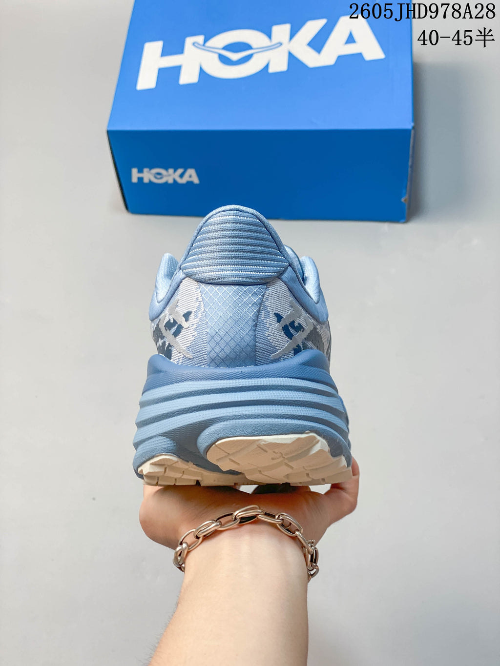 Rear view of the blue HOKA Stinson 7 shoe with a thick heel and treaded sole