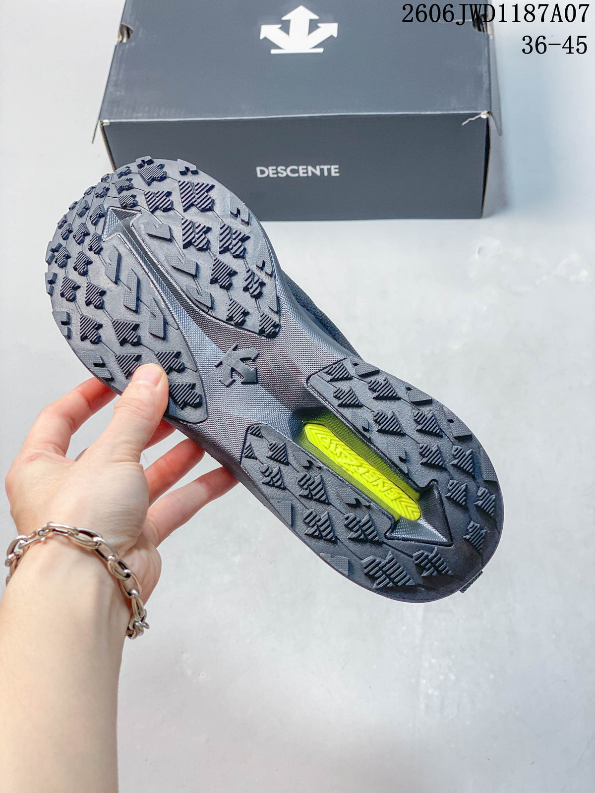 Underside of a dark gray trail sneaker showing a lugged outsole.