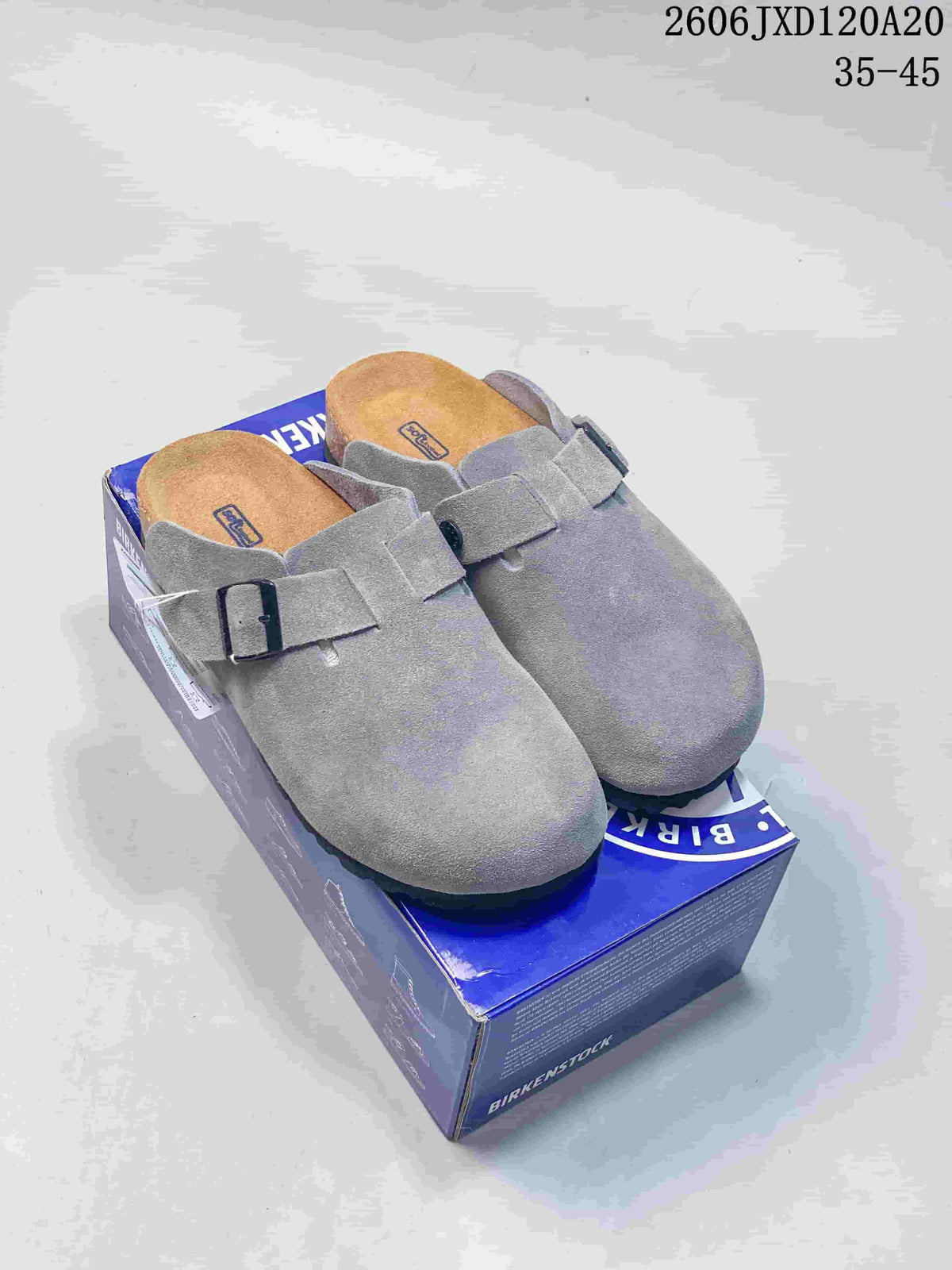 Pair of gray Boston-style clogs with buckle straps on a branded box
