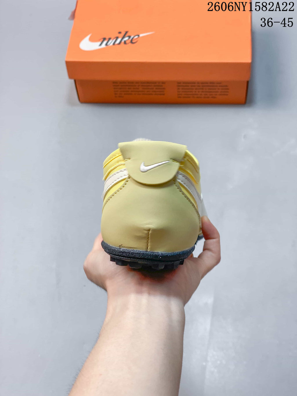 Rear view of a pale yellow Nike Moon Shoe OG sneaker with a small Swoosh detail