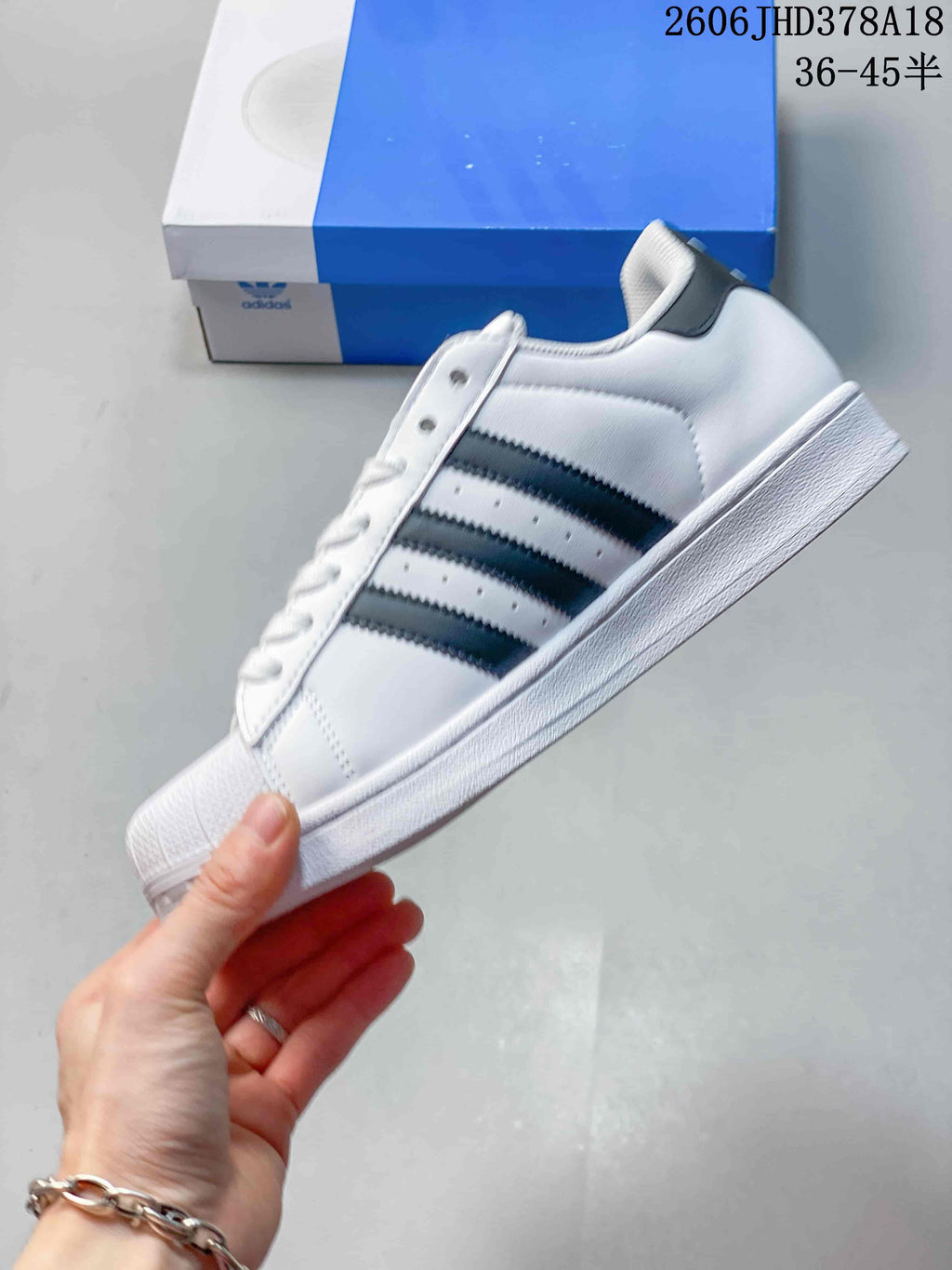 Side profile of the white low-top sneaker with dark stripes