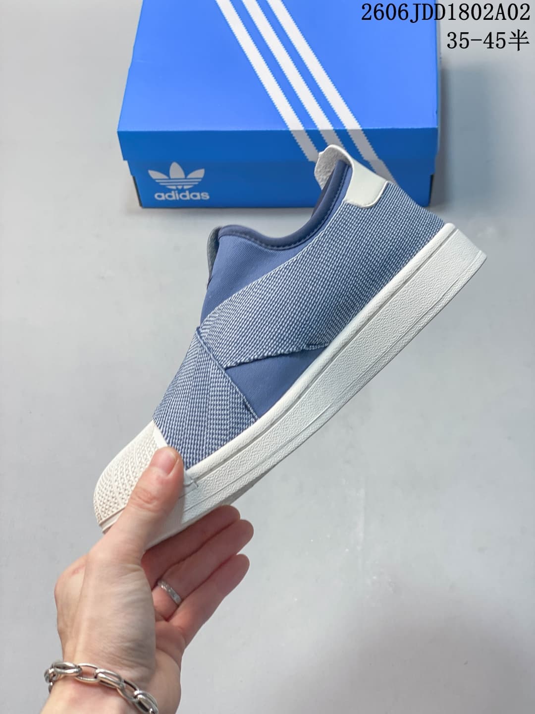 Side profile of the blue and white sneaker showing the low-top silhouette, layered upper panels, white heel tab, and white sole.