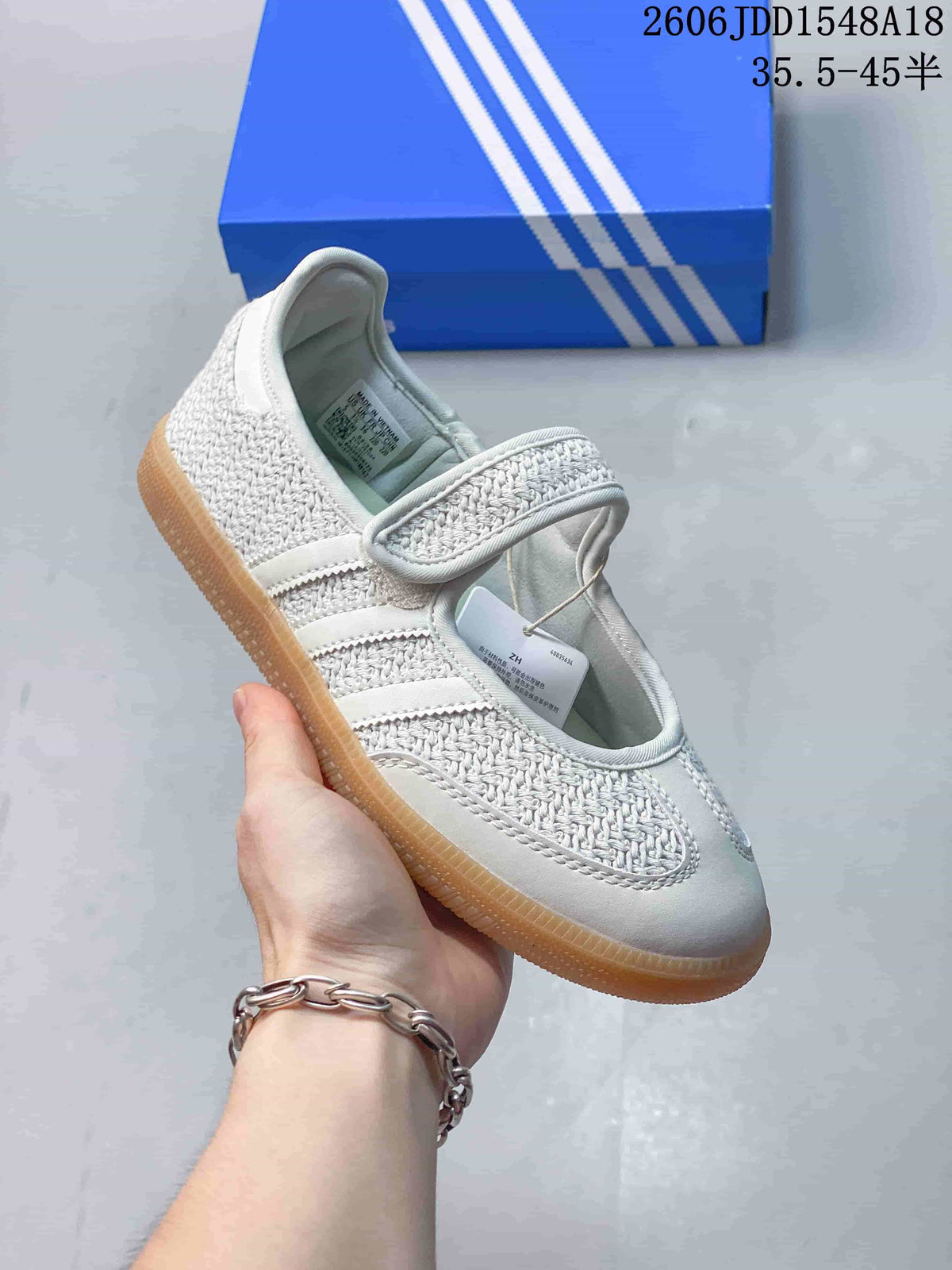 Angled side view of a white Mary Jane-style sneaker with an instep strap and gum-colored sole.