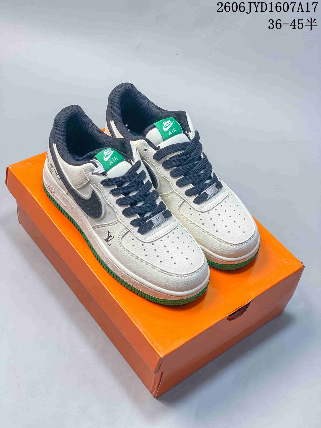 Pair of off-white low-top sneakers with dark laces and green outsole on an orange box