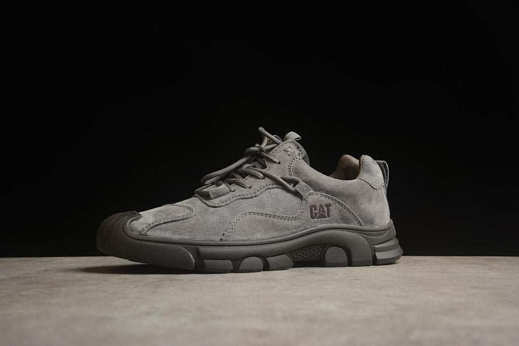 Three-quarter side view of the gray sneaker with CAT branding.
