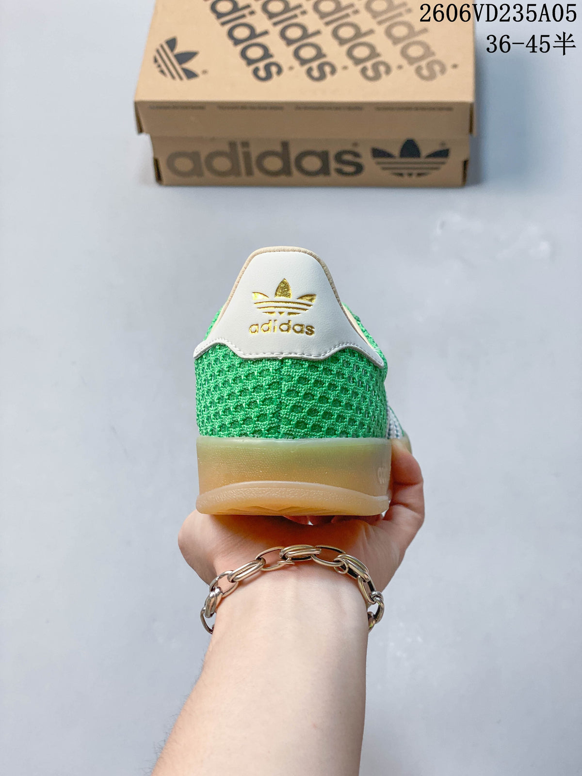 Rear view of the green sneakers showing the white heel panel and gold-colored branding.