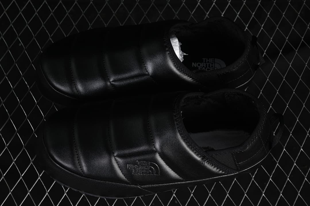 Pair of black slip-on mules viewed from above.