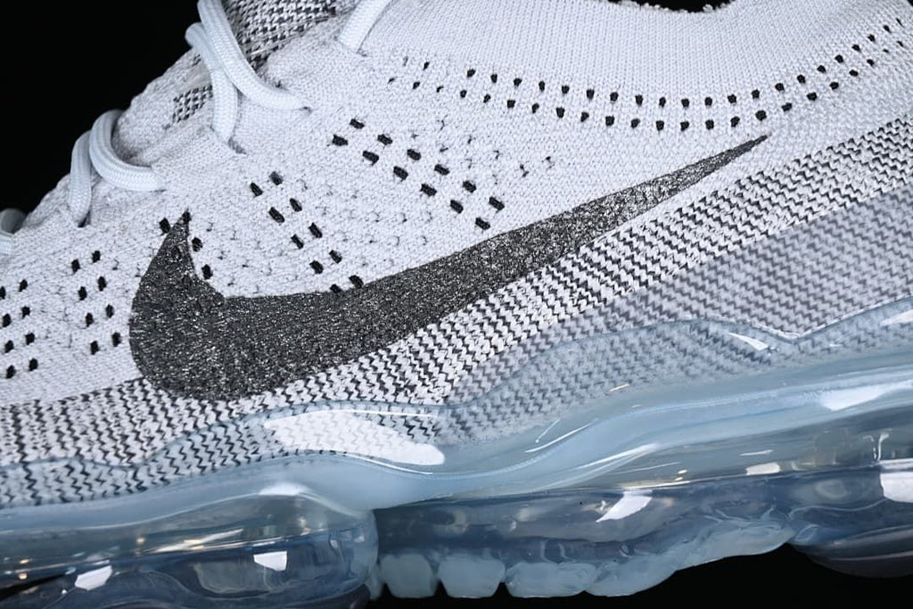 Close-up of the knit-patterned upper, dark Swoosh, and translucent sole.