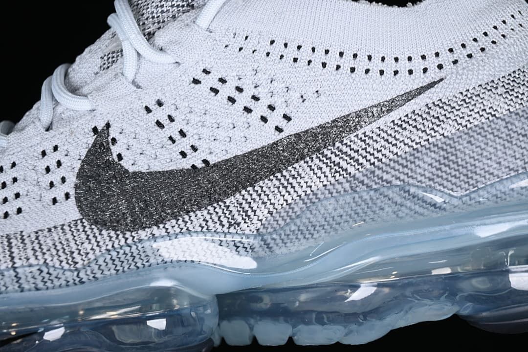 Close-up of the knit-patterned upper, dark Swoosh, and translucent sole.