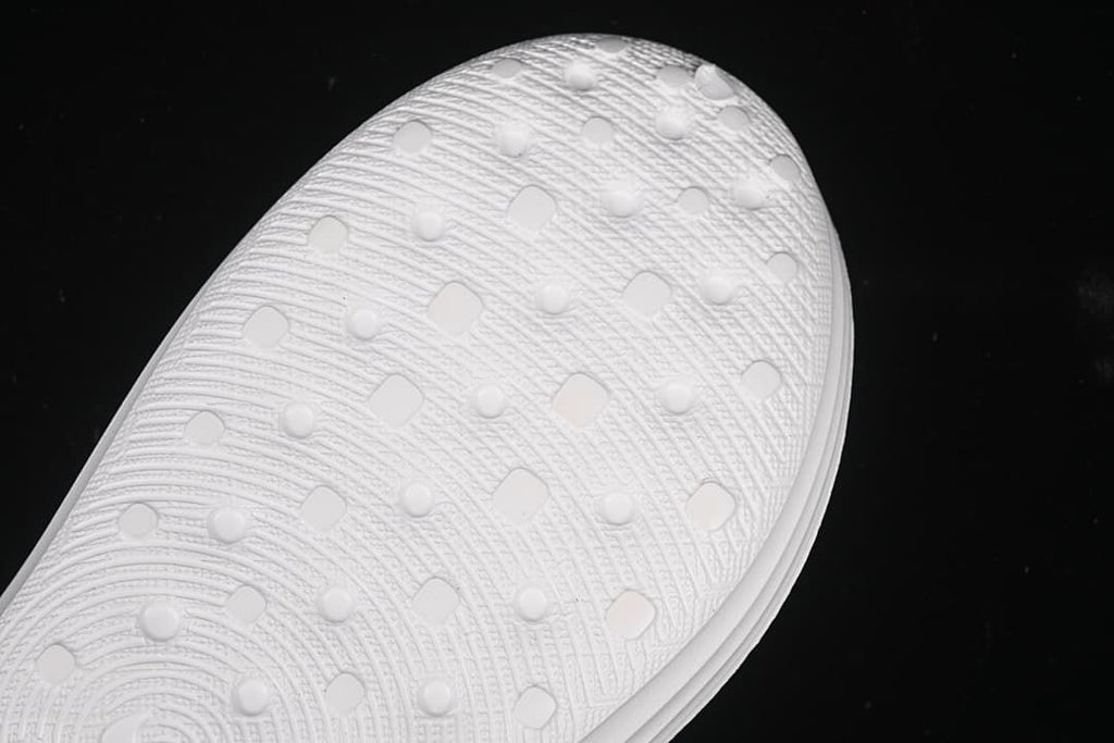Close-up of the textured outsole on the white clog