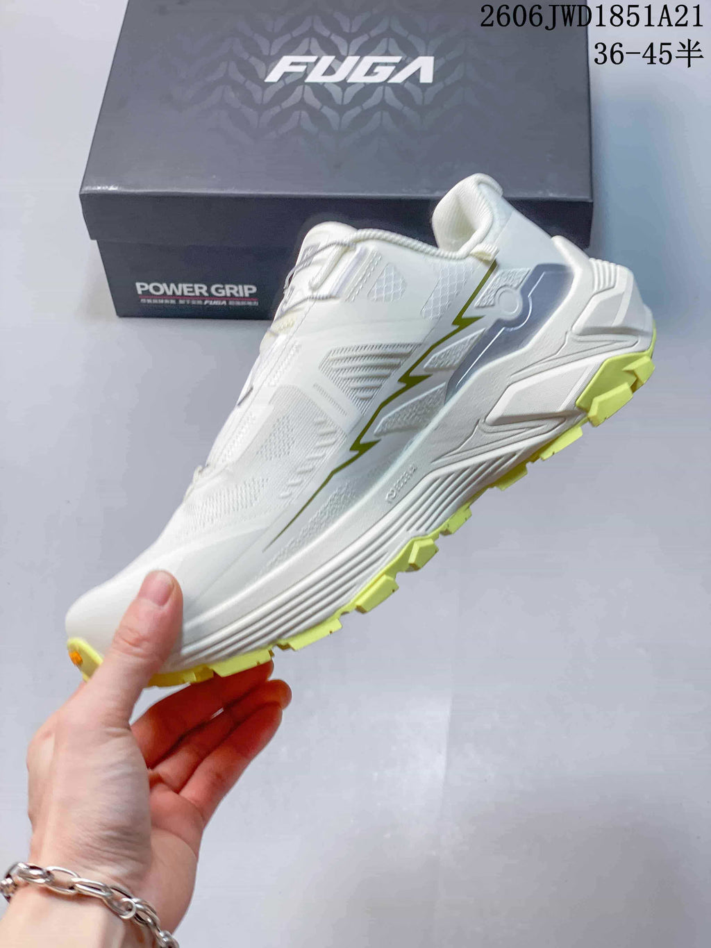 Side view showing the white low-cut shoe and yellow outsole lugs