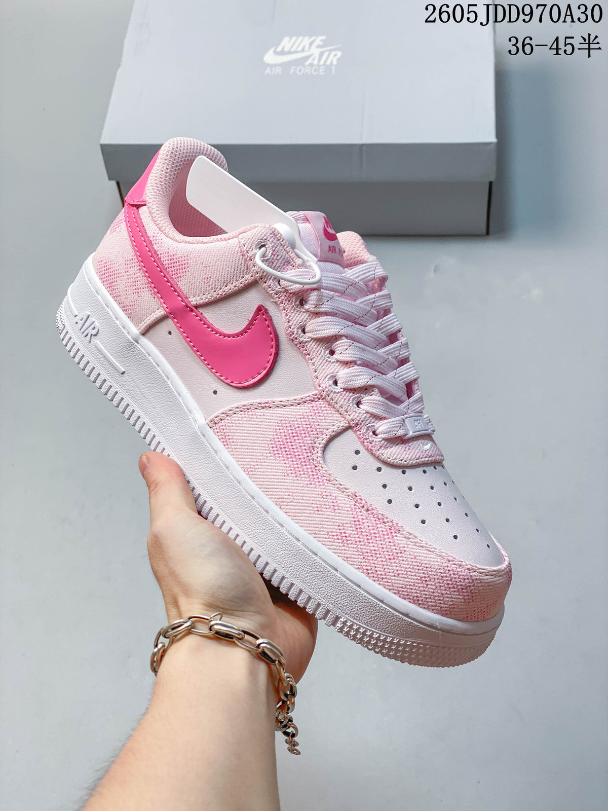 Side view of a pink Nike Air Force 1 ’07 sneaker showing its Swoosh and perforated toe