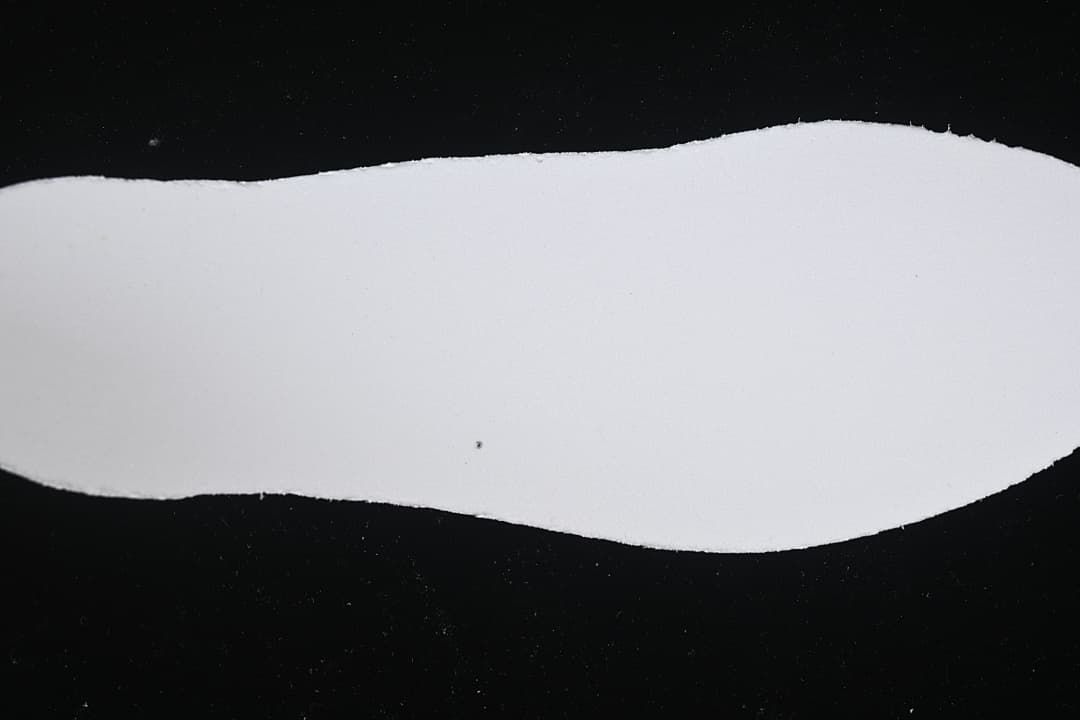 White shoe-shaped cutout shown against a black background