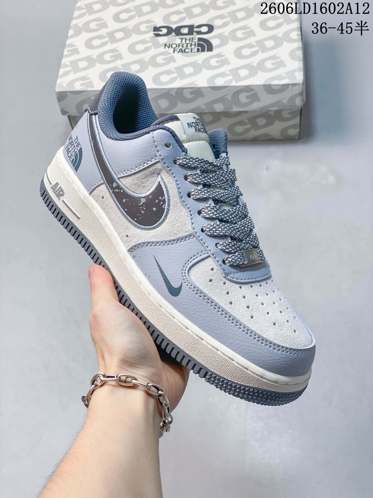 Angled side view showing the pale grey upper, speckled side panel, and dark outsole.