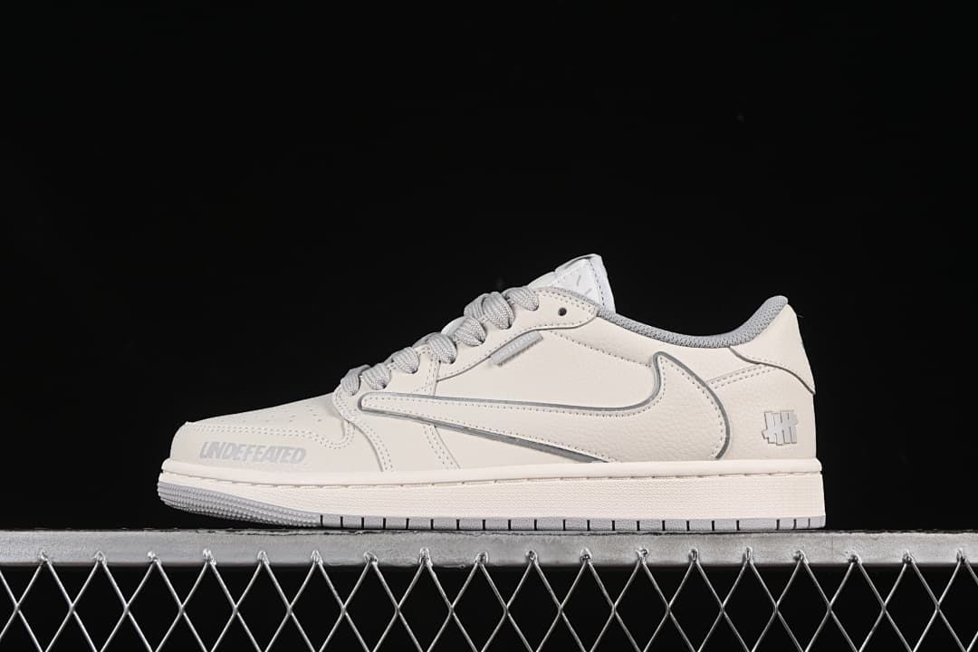 Side view of a light neutral low-top sneaker with gray accents and a prominent side Swoosh.