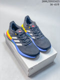 Pair of charcoal Adidas PureBoost 21 shoes with white stripes and a colorful sole, displayed on a shoebox